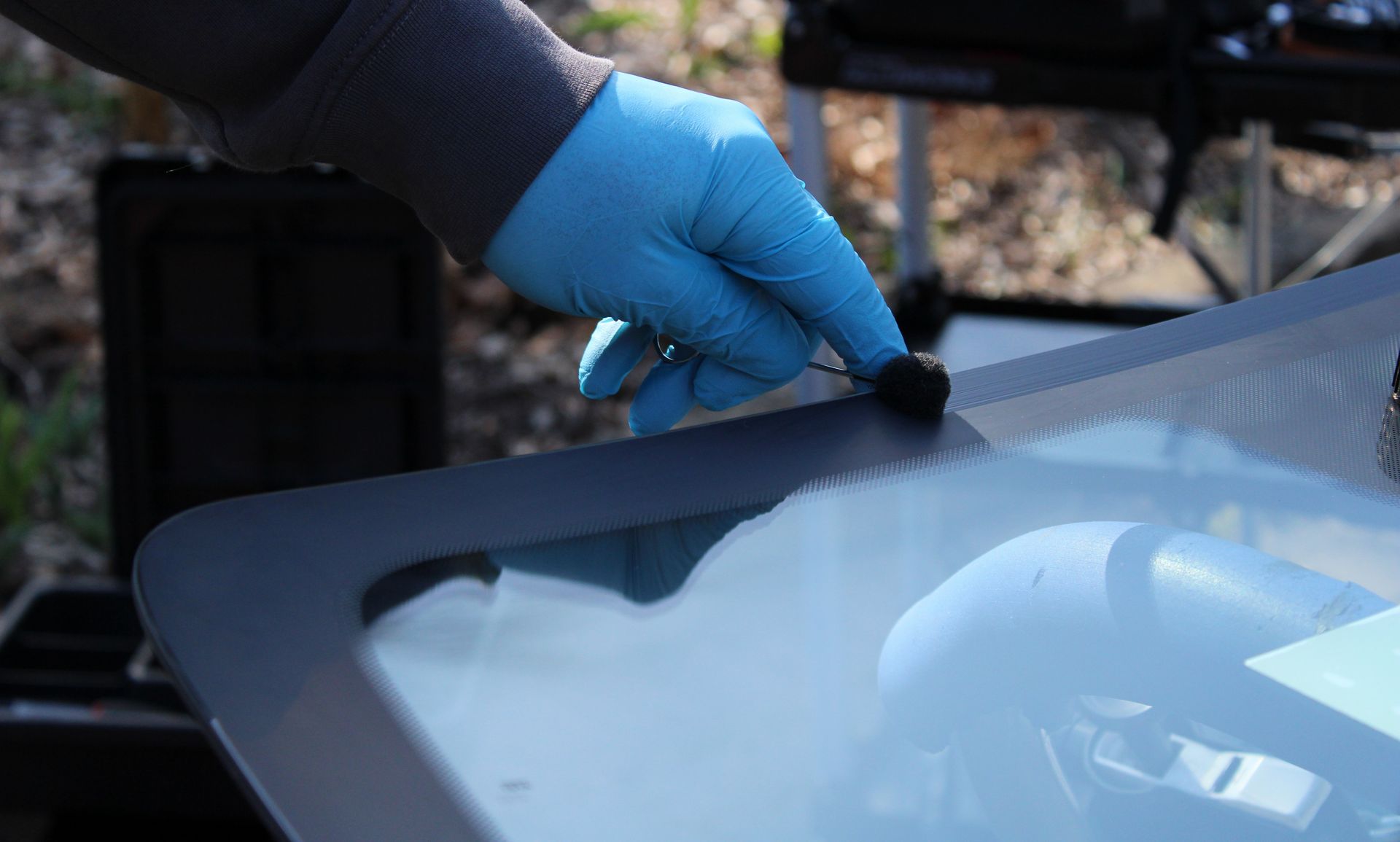 Nahaufnahme einer Windschutzscheiben-Reparatur an einem Fahrzeug.